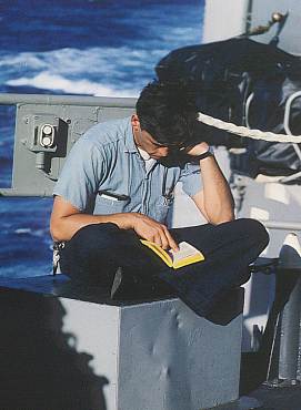 Unidentified sailor reading on the fantail